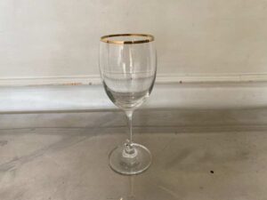 Standard-shaped wine glass with gold rim.
