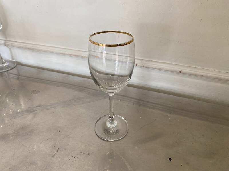 Standard-shaped wine glass with gold rim.