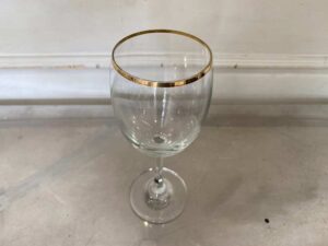 Standard-shaped wine glass with gold rim.