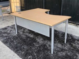 L-shaped work desk, gray steel frame, wooden top.