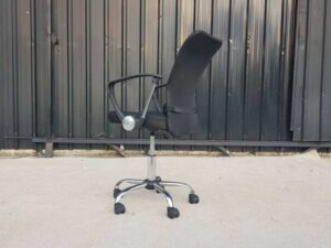 Office chair, fabric upholstery, mesh backrest, steel legs, black color.