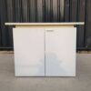 Two-door filing cabinet with wide wooden top, white color.