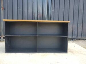 4-shelf black shelf with cream-colored wood top and plywood.