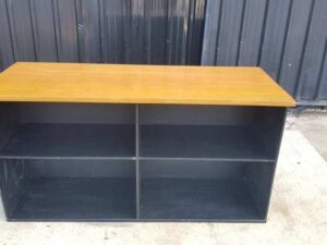 4-shelf black shelf with cream-colored wood top and plywood.