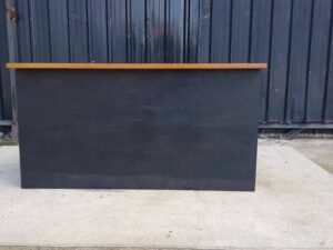 4-shelf black shelf with cream-colored wood top and plywood.