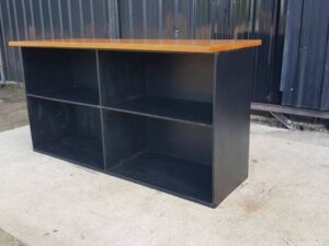 4-shelf black shelf with cream-colored wood top and plywood.