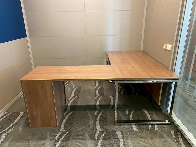 L-shaped corner desk with 3 drawers, steel legs, with rails, and power outlet.