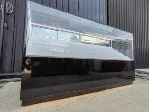 Glass Retail Display Counter with White Tiered Shelves, LED Lighting, and a Glossy Black Base
