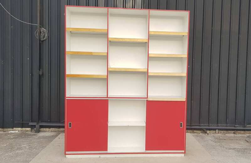 Wooden shelving unit with 2 sliding doors and 13 compartments, white and red.