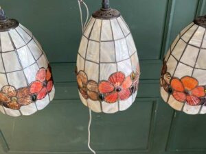 Three pendant ceiling lights with a floral design.