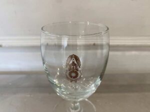 Short-stemmed wine glass with military logo printed on it.