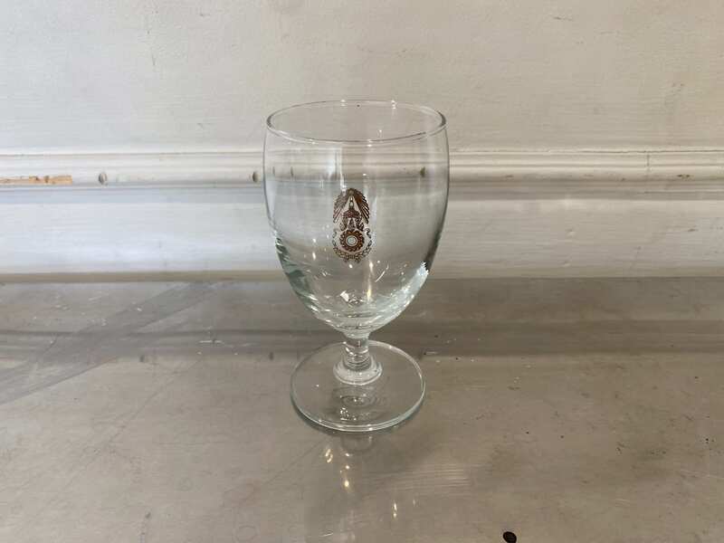 Short-stemmed wine glass with military logo printed on it.