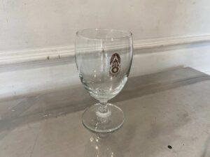 Short-stemmed wine glass with military logo printed on it.