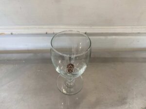 Short-stemmed wine glass with military logo printed on it.