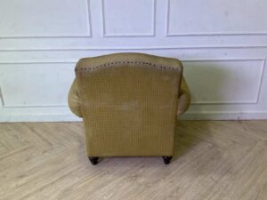 Armchair with wooden legs and brown fabric seat with yellow polka dots._56GGMRE4ZV_LM5WUKN0TZ