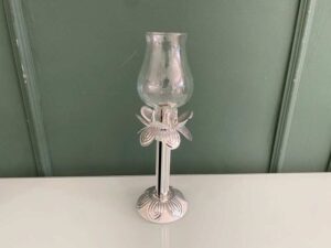 Silver glass-encased candlestick lamp.