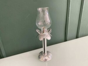 Silver glass-encased candlestick lamp.