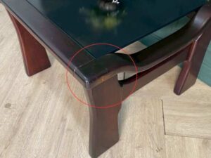 Wooden coffee table with glass top, solid gray color.