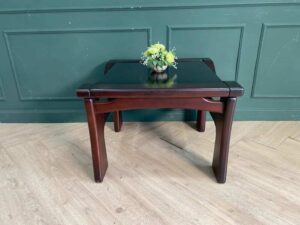 Wooden coffee table with glass top, solid gray color.