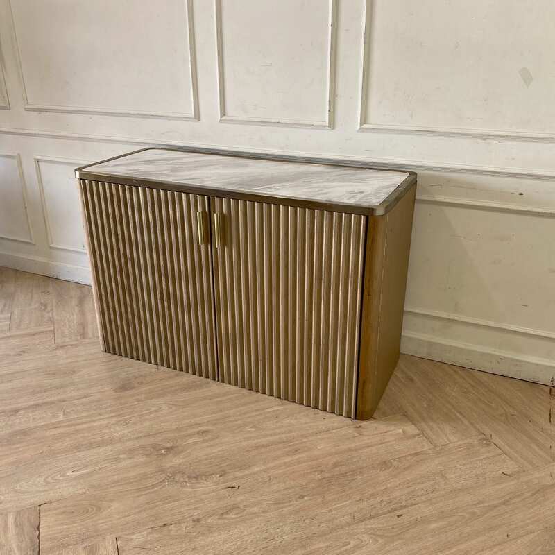 A rectangular, modern luxury wooden cabinet with two doors, in brown with gold stainless steel trim.