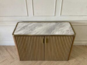 A rectangular, modern luxury wooden cabinet with two doors, in brown with gold stainless steel trim.