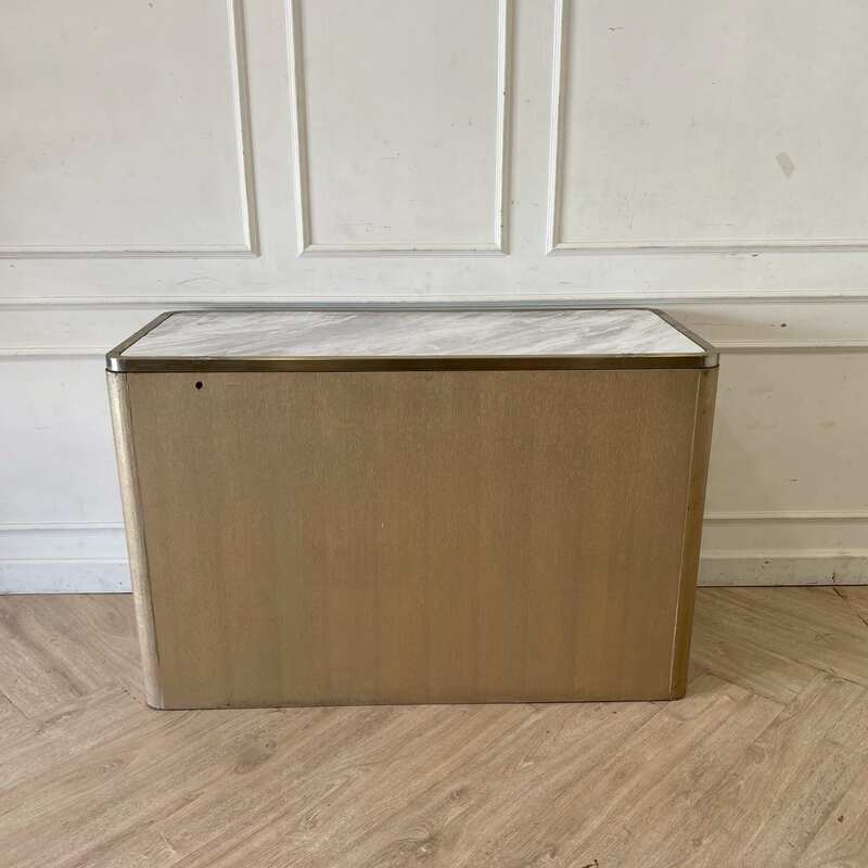 A rectangular, modern luxury wooden cabinet with two doors, in brown with gold stainless steel trim.