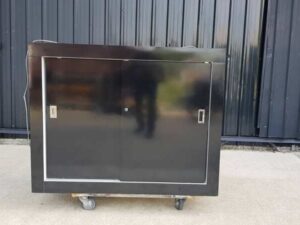 Black wooden dressing table with two sliding doors.