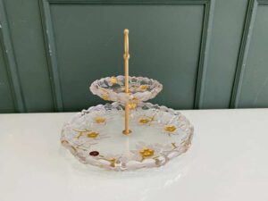 Two-tiered glass dessert and fruit stand with floral design and gold rim, European style.