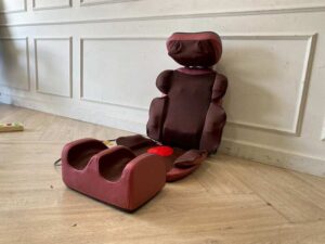 Portable electric massage cushion with remote control, red fabric cushion.