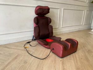 Portable electric massage cushion with remote control, red fabric cushion.
