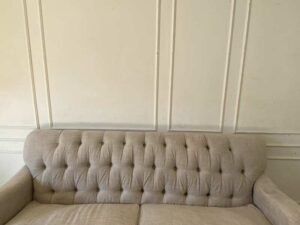 Two-seater sofa, button-tufted fabric upholstery, grey.