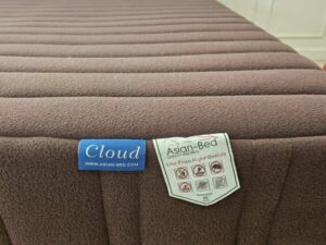 Asian-Bed brand pocket spring mattress with soft, feather-like fabric cover, dark brown color.