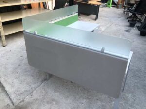 L-shaped corner desk with light gray filing cabinet and partition.