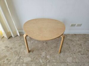 Set of two stacking wooden tables, triangular shape, curved legs, IKEA brand.
