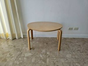 Set of two stacking wooden tables, triangular shape, curved legs, IKEA brand.