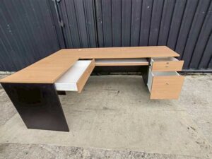 Black L-shaped corner desk with brown wood-tone top; modular/separable
