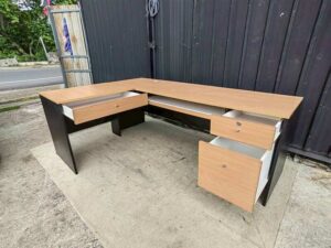 Black L-shaped corner desk with brown wood-tone top; modular/separable
