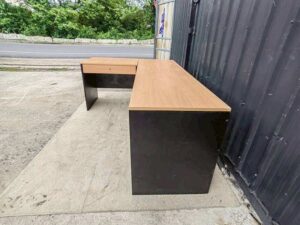 Black L-shaped corner desk with brown wood-tone top; modular/separable