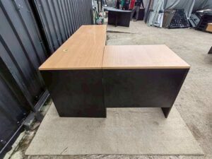 Black L-shaped corner desk with brown wood-tone top; modular/separable