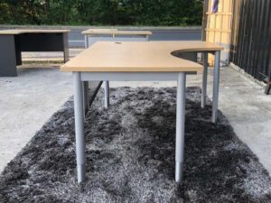 L-shaped work desk, gray steel frame, wooden top.
