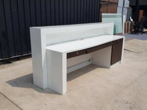 White and brown wooden counter with 3 drawers.