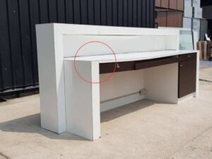White and brown wooden counter with 3 drawers.