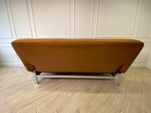 Two-seater sofa bed upholstered in orange fabric, 187 cm.
