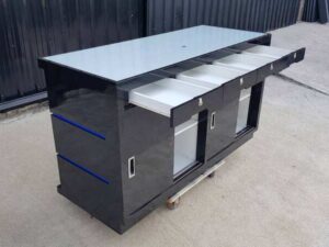 Black wooden counter with 2 sliding doors and 4 drawers.
