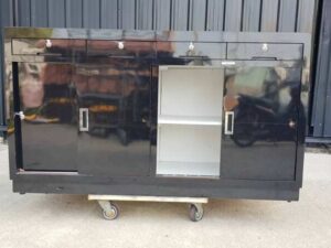 Black wooden counter with 2 sliding doors and 4 drawers.