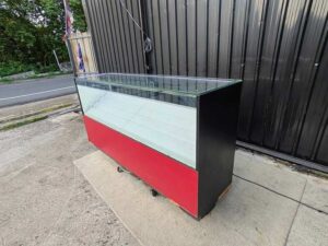 210 cm Red–Black LED Glass Display Counter with White Tiered Shelves and Rear Storage Compartments