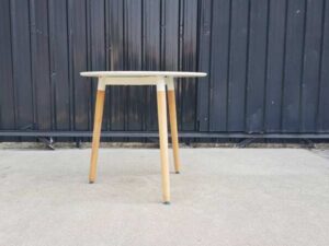 Round table with wooden legs, white color.