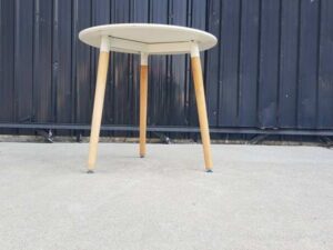 Round table with wooden legs, white color.