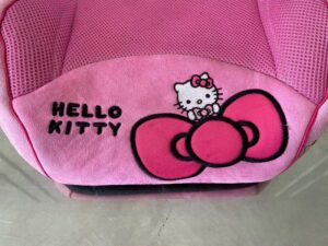 Child car booster seat with Kitty embroidery, pink color.