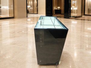 Black glass display cabinet featuring 2 doors, 2 drawers, and 1 storage compartment.